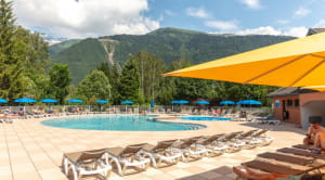 Swimming pool and deckchairs surrounded by mountains